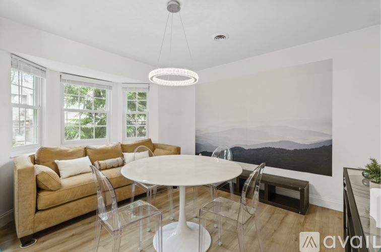 A modern living room with a large couch, a table, and a painting on the wall.