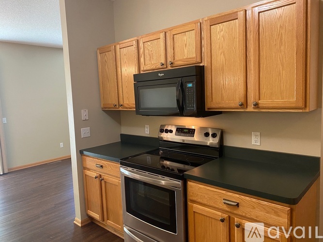 A kitchen with wooden cabinets and black countertops.