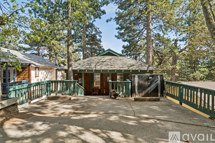A house with a green roof is surrounded by trees.