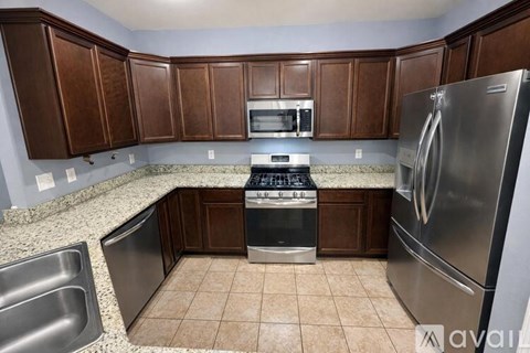 A kitchen with brown cabinets and stainless steel appliances.