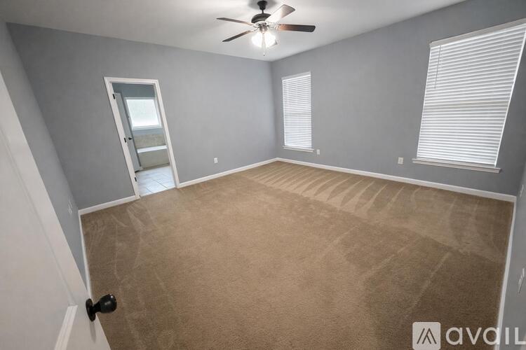 A room with a ceiling fan and carpeted floor.