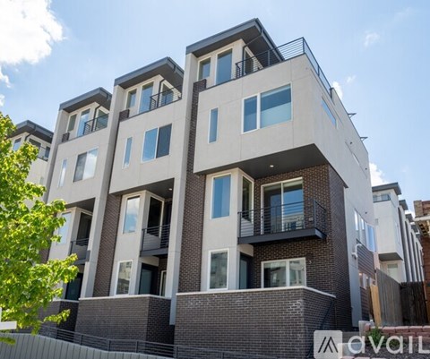 A modern apartment building with balconies and large windows.