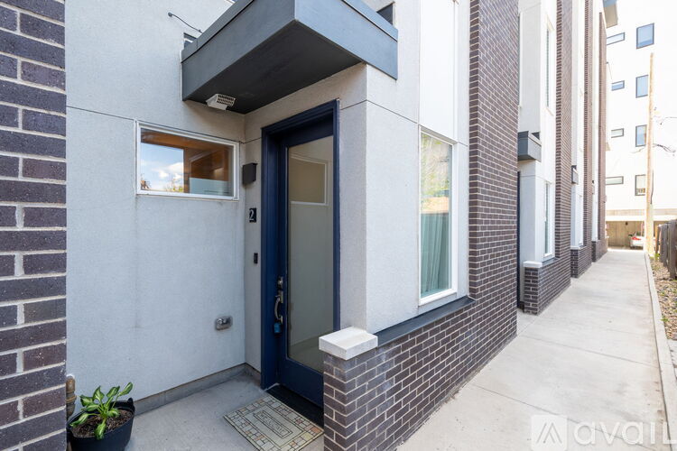 A blue door is on the right side of a white wall.