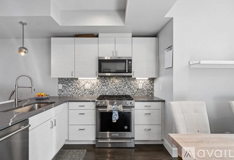 A modern kitchen with white cabinets and stainless steel appliances.