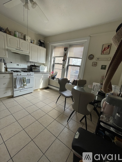 A kitchen with white cabinets and a white stove top oven.