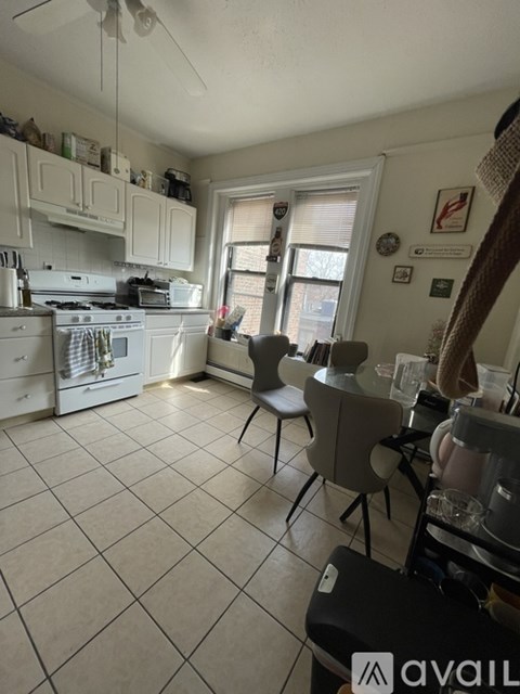 A kitchen with white cabinets and a white stove top oven.