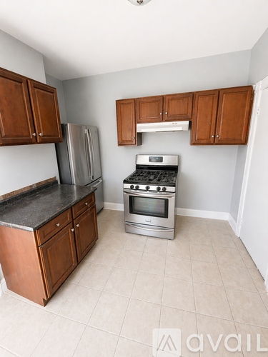 A kitchen with wooden cabinets and a black countertop.