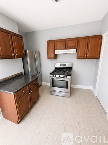 A kitchen with wooden cabinets and a black countertop.