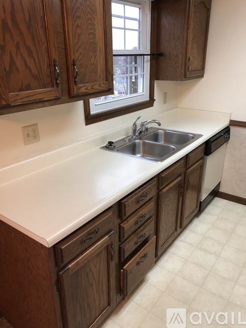 A kitchen with wooden cabinets and a white countertop.