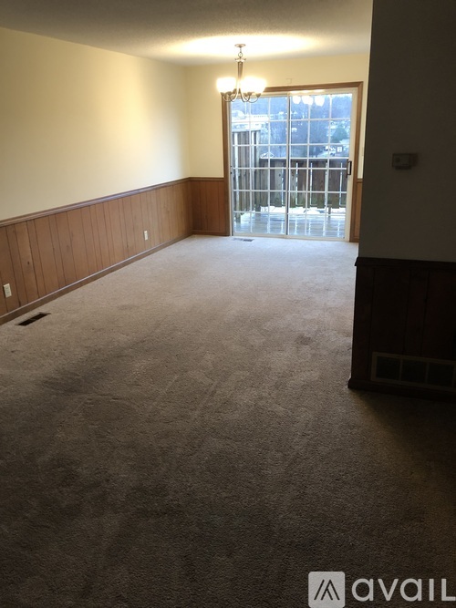A room with a carpeted floor and a chandelier.