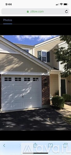 A house with a white garage door and a brick chimney.