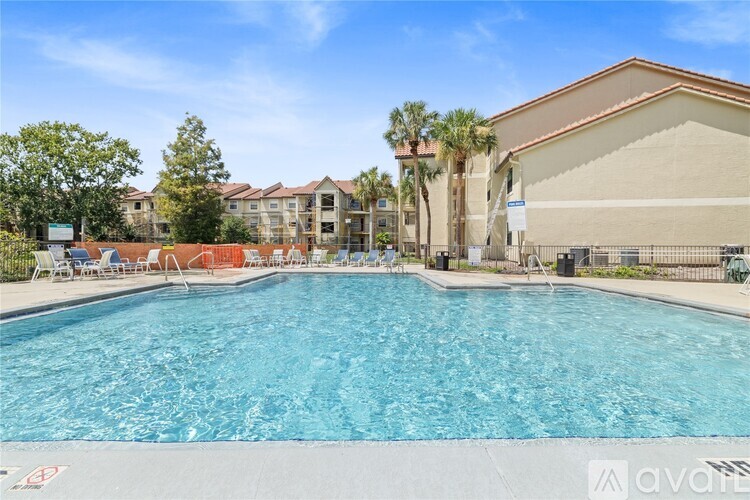 A large swimming pool in front of a building with a clear blue sky above.