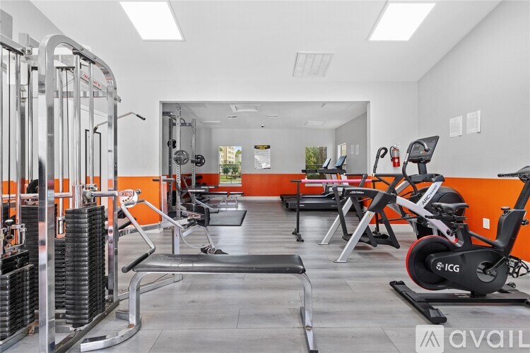 A gym with orange walls and a variety of equipment.