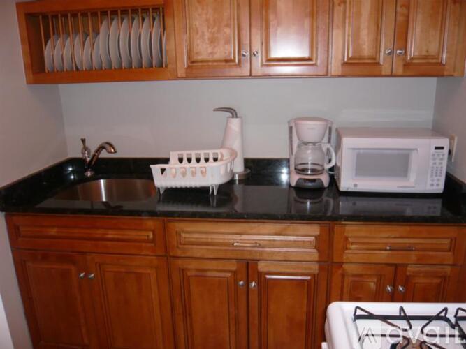 A kitchen with wooden cabinets and a black countertop.