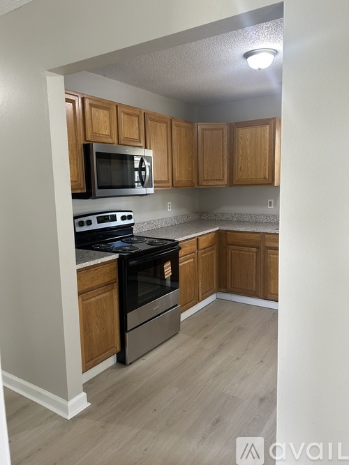 A kitchen with wooden cabinets and a black stove top oven.