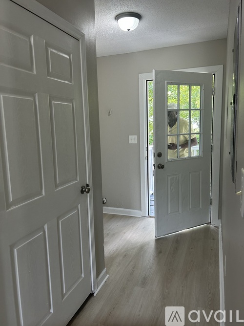 A hallway with a white door and a white door frame.