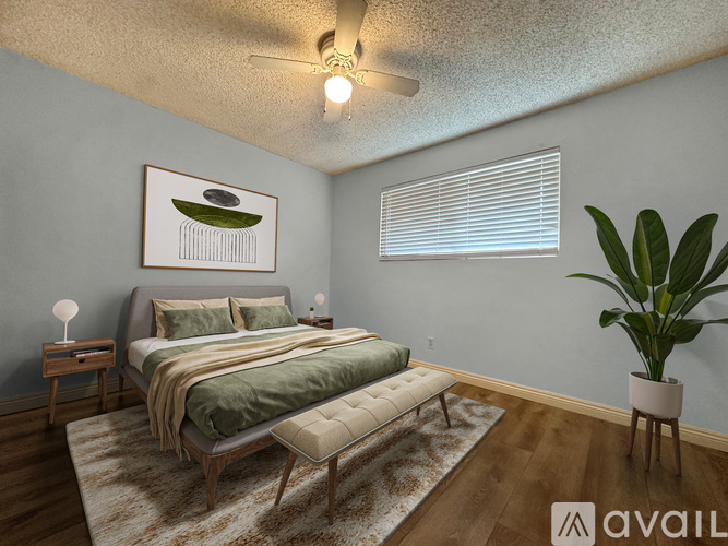 A bedroom with a bed, a bench, and a plant.