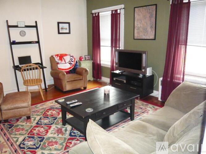 A living room with a couch, chair, and television.