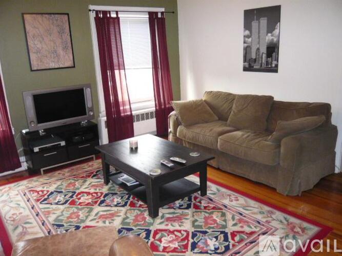 A living room with a brown couch, a coffee table, and a television.