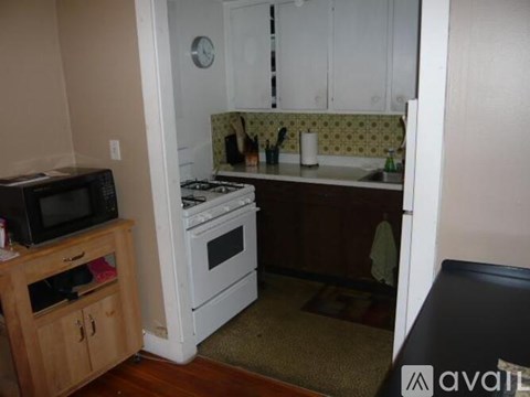 A kitchen with a stove, microwave, and cabinets.