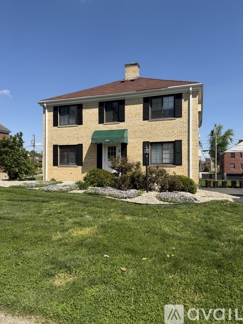 A house with a green awning is for sale.