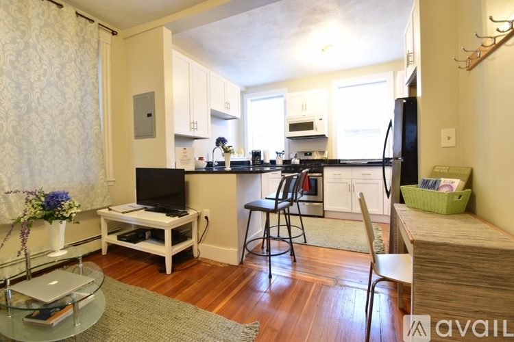 A kitchen with a black refrigerator and white cabinets.