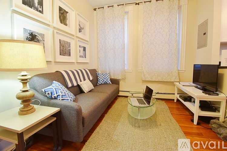 A living room with a grey couch and a glass coffee table.