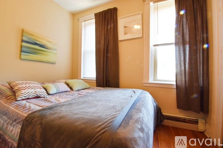 A bedroom with a large bed and a painting on the wall.