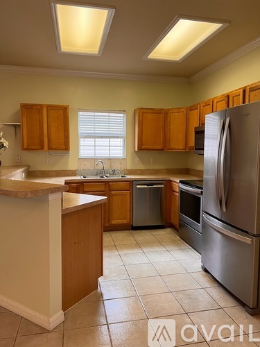A kitchen with wooden cabinets and a refrigerator.