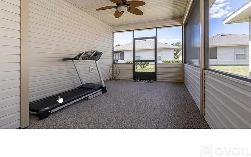 A room with a treadmill and a ceiling fan.