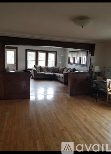 A living room with a couch, chair, and desk.