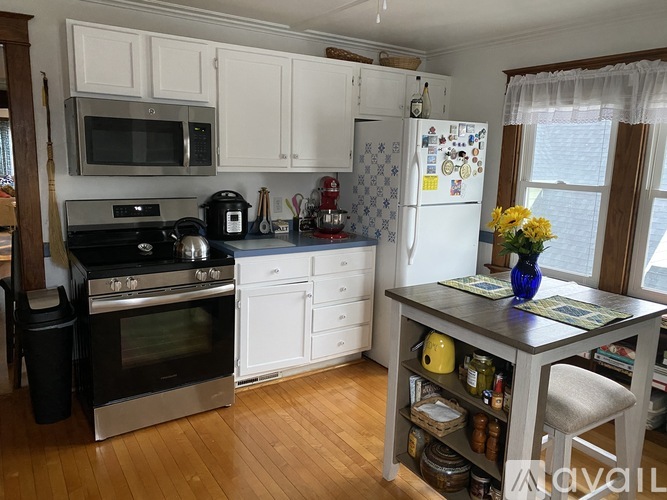 A kitchen with a black stove top oven and white cabinets.