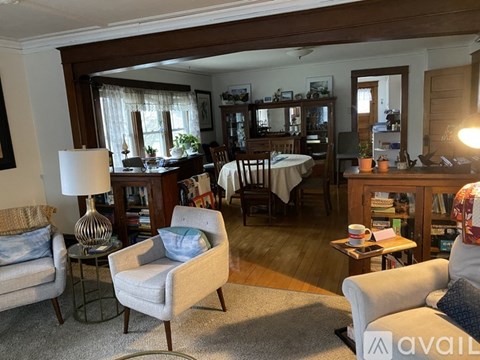 A living room with a couch, chair, and a table with a lamp on it.