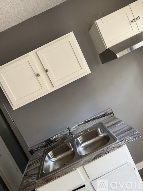 A kitchen with a marble countertop and two sinks.