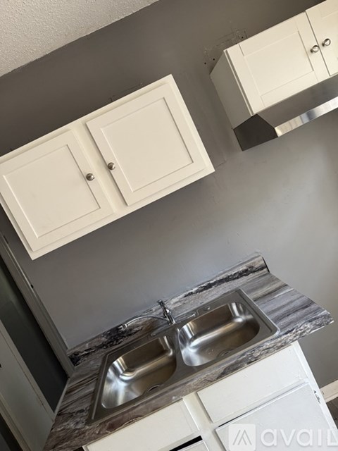 A kitchen with a marble countertop and two sinks.
