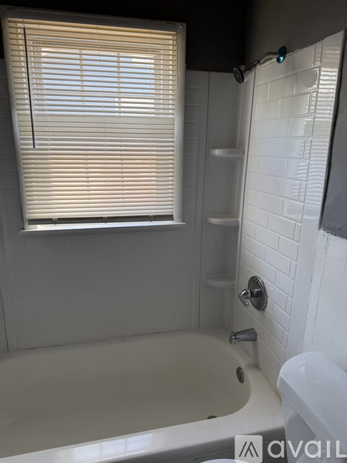 A bathroom with a tub, toilet, and sink.