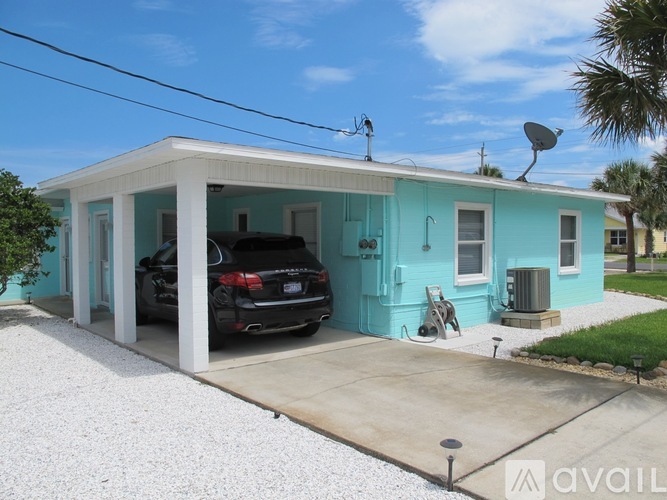 A blue house with a black car parked in front.
