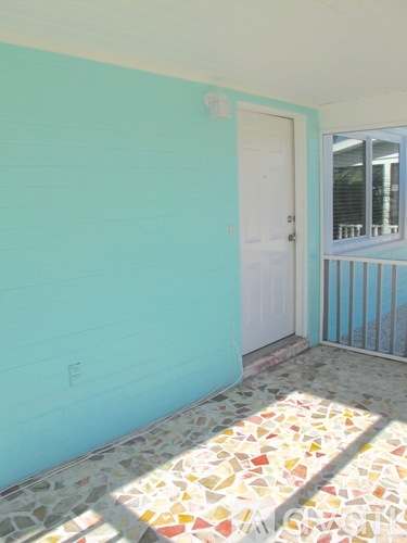 A room with a white door and a tiled floor.