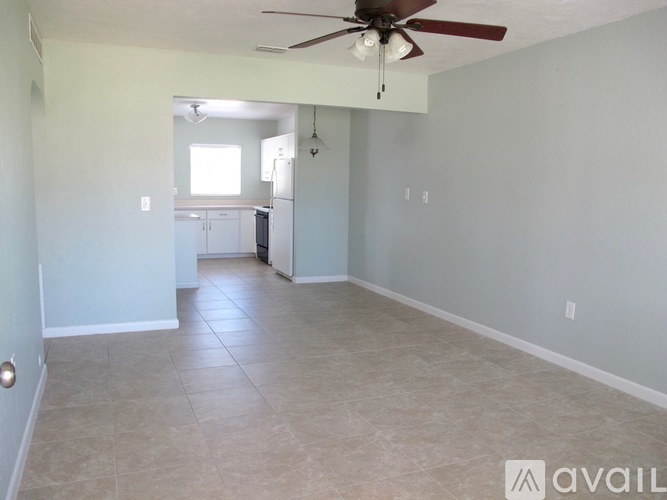 A spacious room with a ceiling fan and tile flooring.