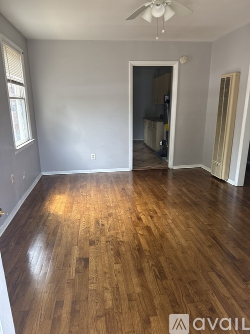 A room with wooden flooring and a ceiling fan.