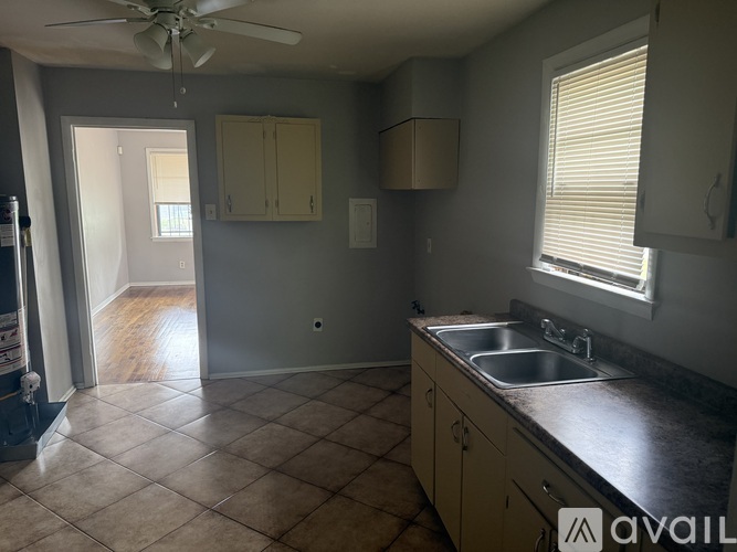 A kitchen with a sink, a window, and a ceiling fan.