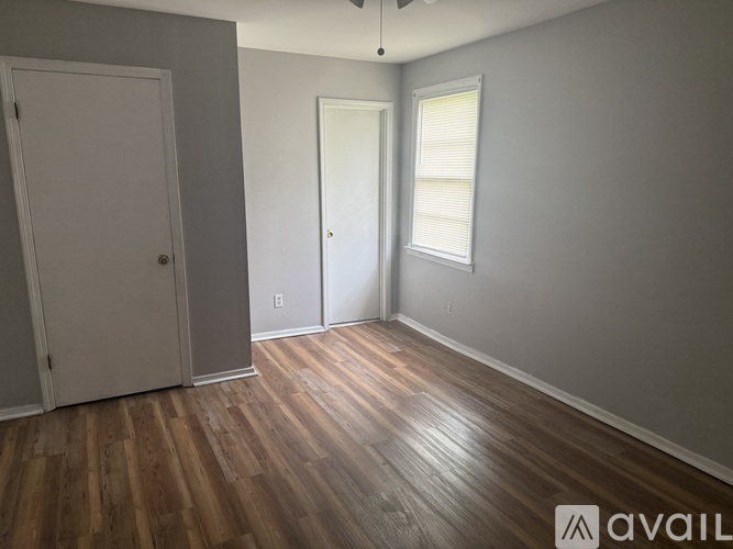 A room with wooden floors and two doors.