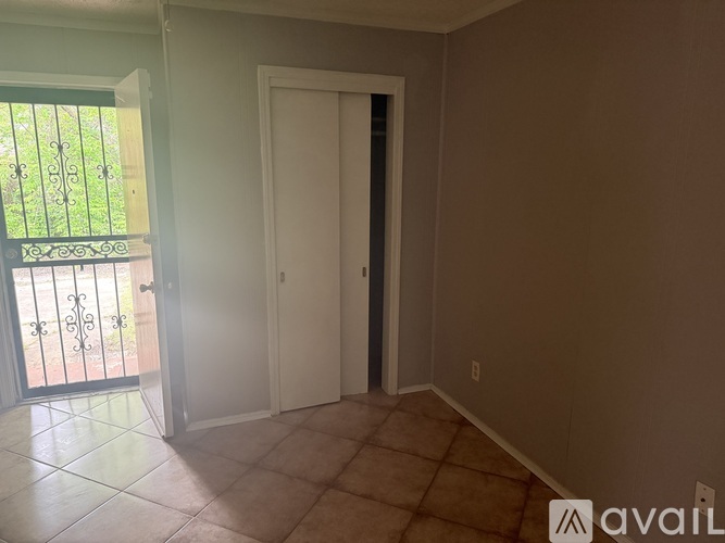 A room with a white door and a balcony with a black railing.