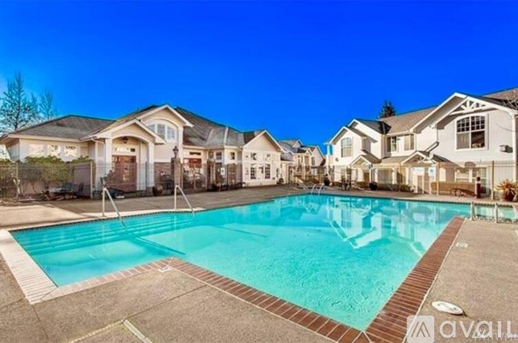 A swimming pool in front of a row of houses.