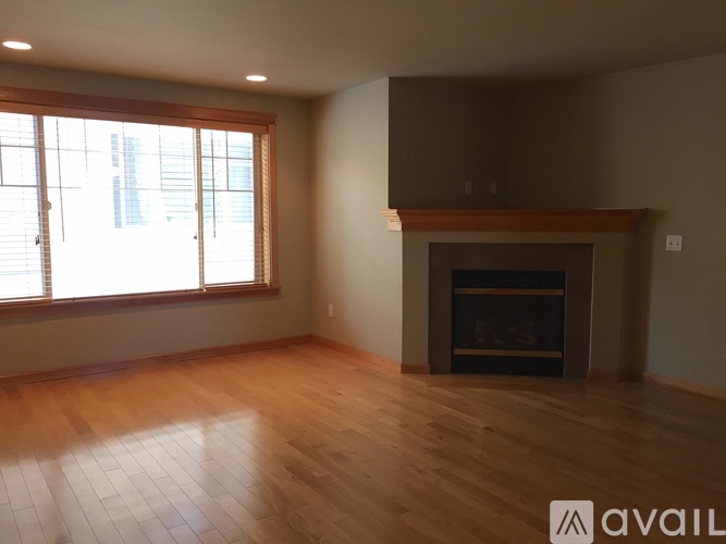 A room with a fireplace and wooden flooring.