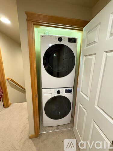 A white front loading washing machine in a laundry room.