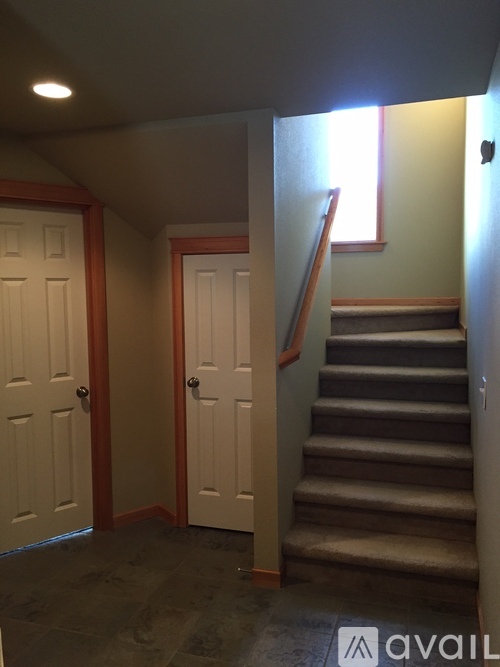 A hallway with a staircase and two doors.