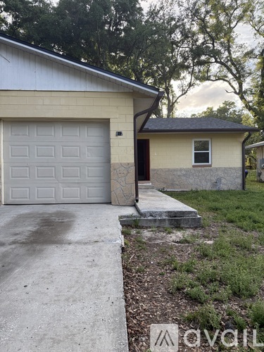 A house with a white garage door and a brown door.