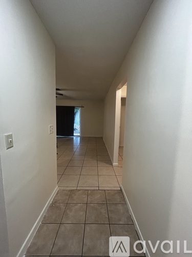 A long hallway with tiled floors and white walls.