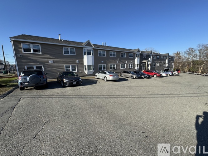 A parking lot with cars and apartment buildings in the background.